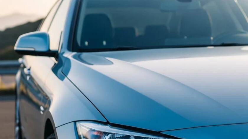 Shiny car with ceramic coating in a scenic outdoor setting, highlighting paint protection benefits