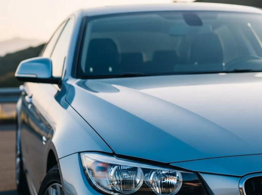 Shiny car with ceramic coating in a scenic outdoor setting, highlighting paint protection benefits