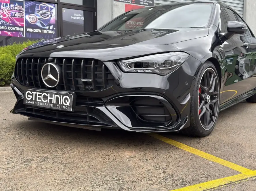 Black Mercedes-Benz AMG car with Gtechniq plate outside a detailing shop.