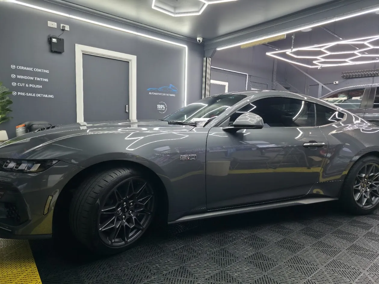 Technician vacuuming the interior of a car, emphasizing the meticulous cleaning process for vehicle resale