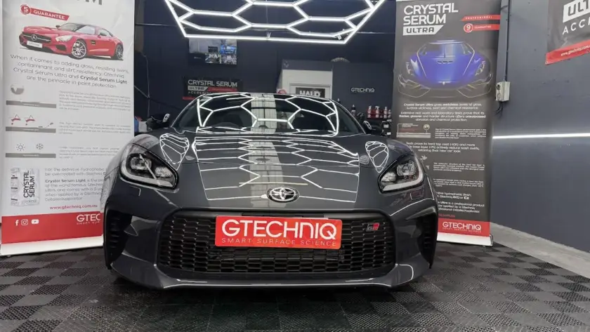 Professional applying Gtechniq ceramic coating in a garage setting